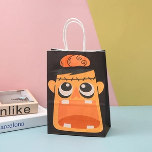 Close-up of a black Halloween gift bag with a vibrant orange cartoon monster face and handles
