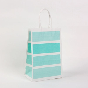 Detailansicht einer Geschenktüte aus weißem Kraftpapier mit blauen Streifen und Griffen