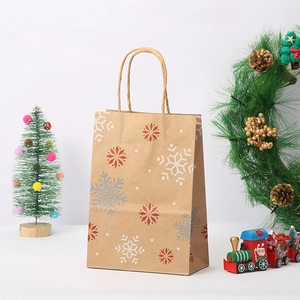 Detail view of brown kraft paper Christmas gift bag featuring white and red snowflake patterns