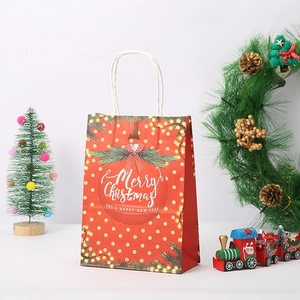 Christmas kraft paper gift bag with red polka dots and festive Merry Christmas print