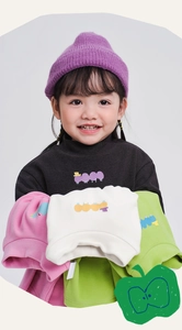 Dettaglio di t-shirt in pile da bambino in nero, rosa, beige e verde con stampa amila