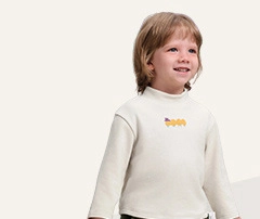 Dettaglio di felpa beige per bambini con collo alto e stampa astratta gialla sul petto