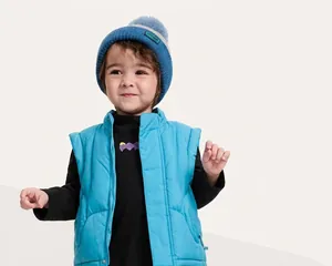 Dettaglio del gilet imbottito blu per bambini con tessuto impermeabile e antivento
