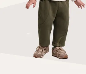Dettaglio dei pantaloni jogger verdi oliva per bambini con elastico in vita e cuciture
