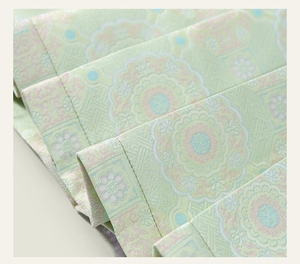 Primer plano de tela jacquard verde claro con motivos florales chinos tradicionales