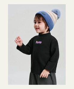 Dettaglio bambino con felpa nera a lupetto, stampa nuvola viola e cappello in maglia