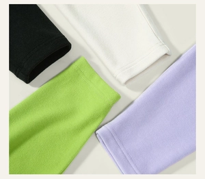 Dettaglio dei polsini a costine multicolore in nero, crema, verde e viola con pile
