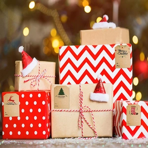 Kraft Christmas gift tags with reindeer and tree designs on wrapped holiday parcels