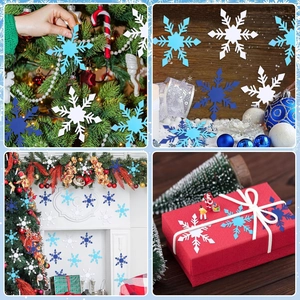 Dettagli di ritagli di fiocchi di neve blu e bianchi che decorano l'albero di Natale