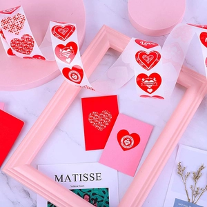 Rolle mit roten und rosa herzförmigen Valentinstag-Aufklebern für Geschenke und Umschläge