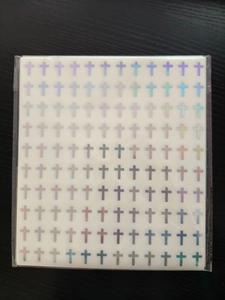 Makro-Detail von holografischen Kreuz-Aufklebern mit metallischem Laser-Finish für Alben