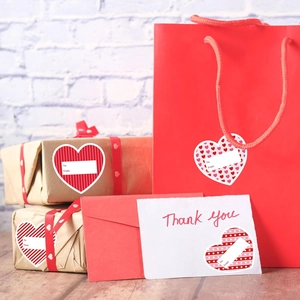 Détail d'autocollants cadeaux en forme de cœur avec texte To/From pour la Saint-Valentin