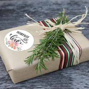 Handmade with love round floral stickers on kraft gift box with festive ribbon