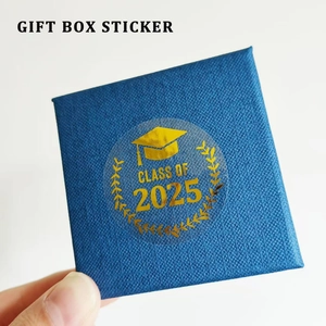 Transparent gold foil Class of 2025 graduation stickers on blue gift box lid
