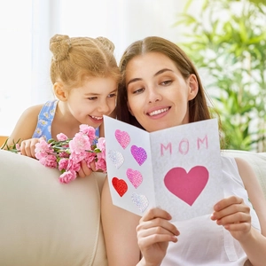 Mother's Day greeting card with laser heart stickers and MOM lettering shown with family