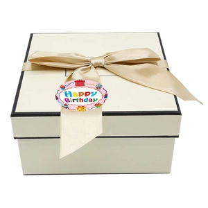 Detail of a round Happy Birthday sticker with cupcake motifs on a gift box ribbon