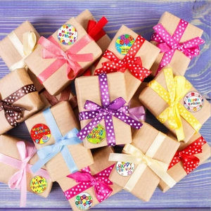 Assorted Happy Birthday stickers with balloons on gift boxes over purple wood background