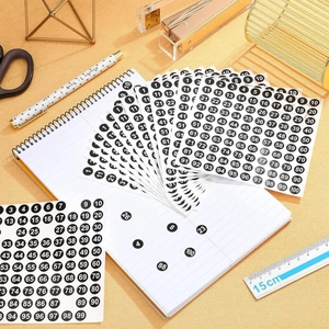 Detailed view of 10mm round numbered stickers 1-100 on desk with stationery items