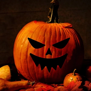 Halloween DIY pumpkin decoration featuring a jack-o'-lantern with spooky face and fall leaves