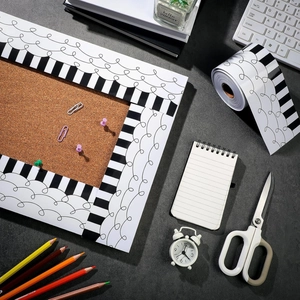 Black and white striped scalloped bulletin border stickers displayed on a cork board
