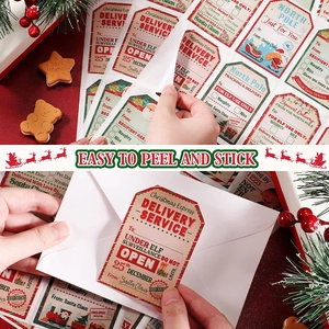 Detail of Christmas gift labels being peeled and applied to white holiday envelopes