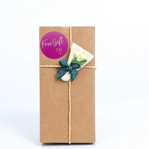 Brown kraft gift box with beige string, dried flowers, and a purple Free Gift sticker