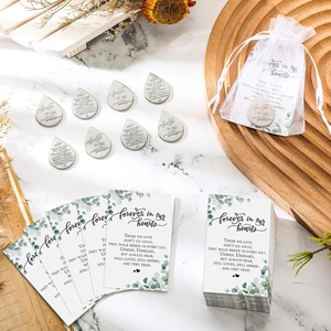 Funeral prayer cards with silver memorial coins and white organza bags for bereavement gifts