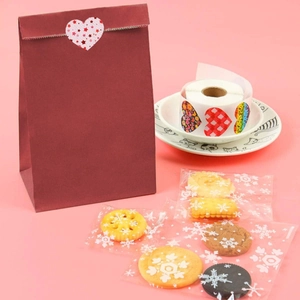 Detail of heart gift stickers on red paper bags and cookie packaging for Valentine's Day