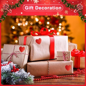 Détail d'autocollants cœurs rouges pailletés scellant des boîtes cadeaux en papier kraft
