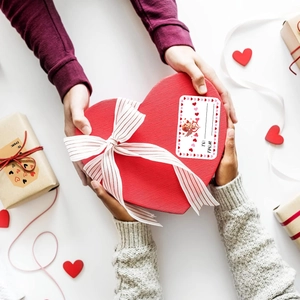 Makroaufnahme quadratischer Happy Valentine's Day Aufkleber auf einer roten Geschenkbox