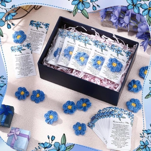 Detail of handcrafted blue forget-me-not crochet flowers with a memorial poem card