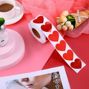 Close-up of heart-shaped glitter stickers in a roll on a romantic decorative background