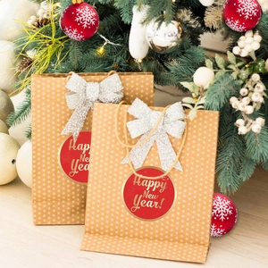 Brown polka dot paper gift bags with silver bows and Happy New Year tags in festive setting