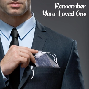 Blue heart memorial pendant with organza bag shown in a dark suit pocket for bereavement