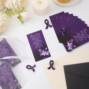 Memorial set with purple ribbon enamel pin, verse card, and white organza bag on a desk