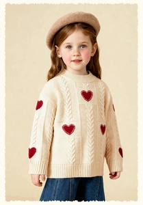 Detail of child knit sweater with red hearts and classic cable knit texture