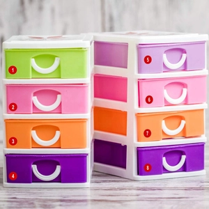 Detailed view of colorful four-layer plastic desktop storage boxes on a wooden surface