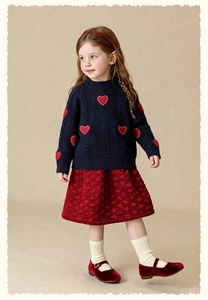 Full view of navy knit sweater with red hearts and textured skirt for kids