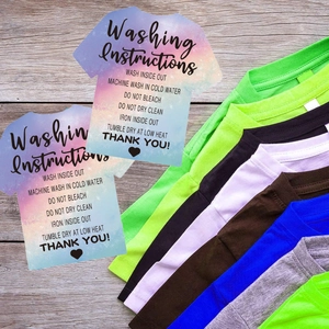 Macro view of watercolor T-shirt washing instruction cards with laundry care icons