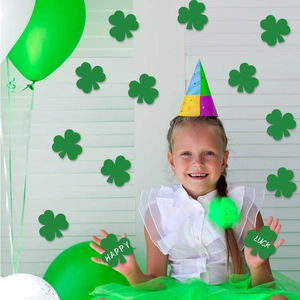 Meisje met feesthoedje en groene klaveruitsnijdingen voor St. Patrick's Day