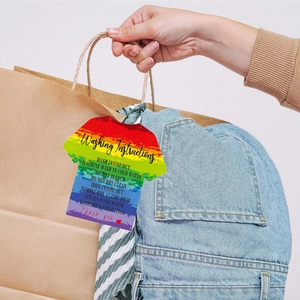 Macro detail of T-shirt shaped rainbow washing instruction tag on denim clothing