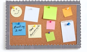 Close-up of cork bulletin board featuring wavy checkered border and colorful notes