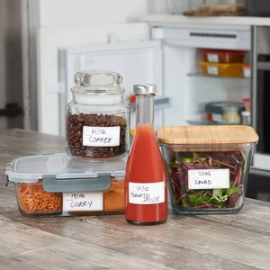 Waterproof rectangular labels for kitchen jars and food containers on a grey wood surface