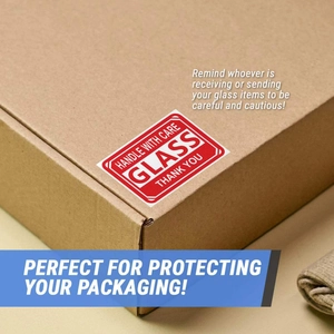 Detail of red Glass Handle With Care fragile warning sticker on a cardboard shipping box