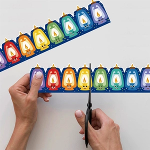 Colorful lantern pattern bulletin board border stickers being cut with scissors