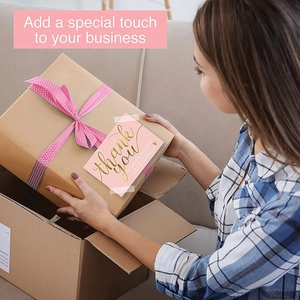 Pink Thank You card with gold script on a brown gift box with polka dot ribbon