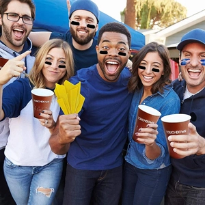 Grupo de amigos con pegatinas negras en los ojos durante una fiesta de fútbol al aire libre