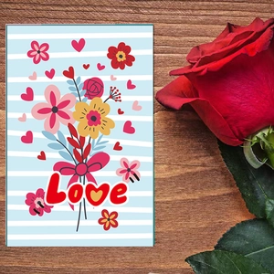 Detail van Valentijnskaart met boeket en tekst Love op houten achtergrond met een roos