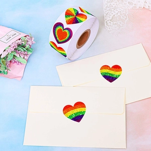 Rainbow heart stickers with laser glitter effect on envelope with flowers background