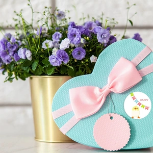 Heart-shaped light blue Easter gift box with Happy Easter sticker and pink ribbon bow
